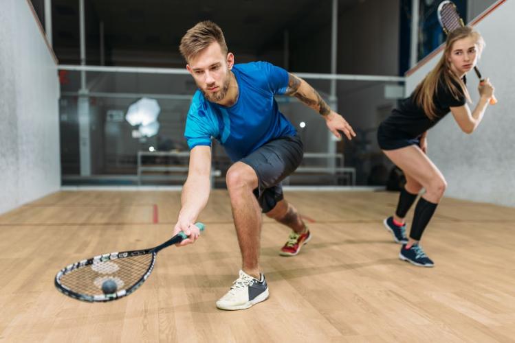 A man and a woman playing squash