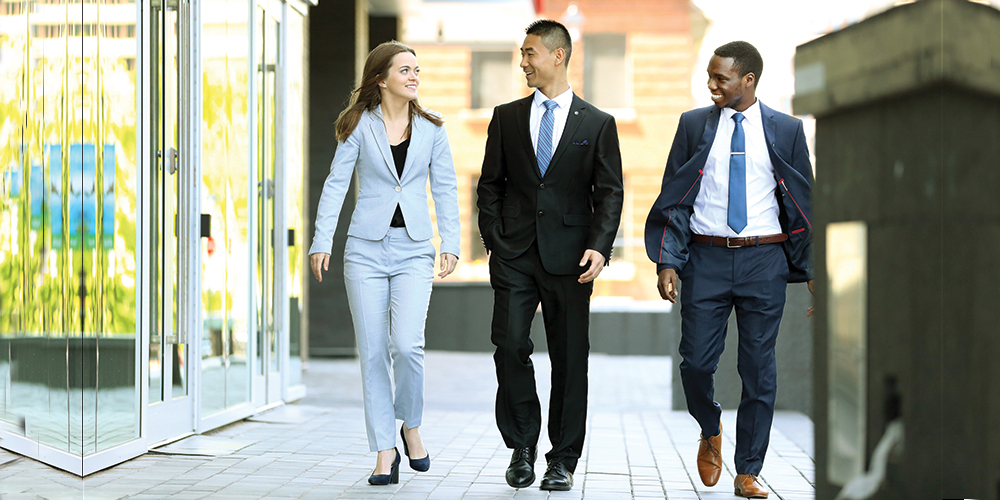 Three well-dressed students walking together.